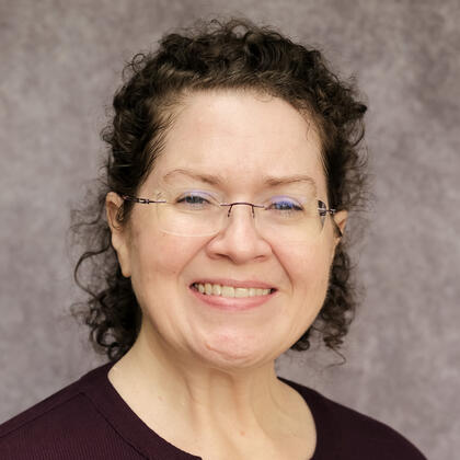 Nikki Rehman Headshot of Nikki Rehman, a smiling woman with short, curly hair and glasses.